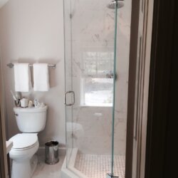 Glass door corner shower in remodeled bathroom