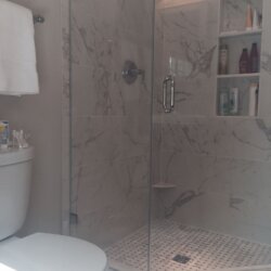 Glass door corner shower in remodeled bathroom