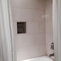 White tile bath/shower combo in finished basement bathroom