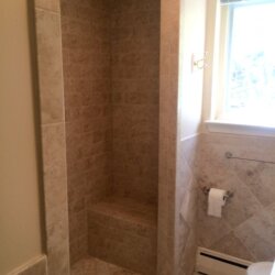 Beige tile shower with built-in bench