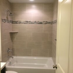 Shower in remodeled bathroom with matchstick tile accents