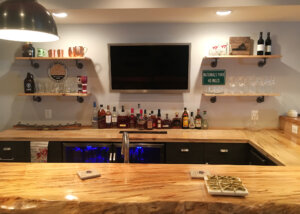 Home bar in finished basement with natural edge wood bar top