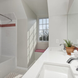 Bathroom with red accent tiles and two faucets