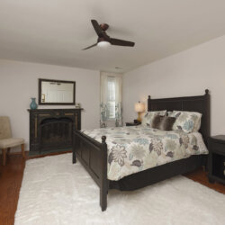 Guest bedroom with fireplace and white rug
