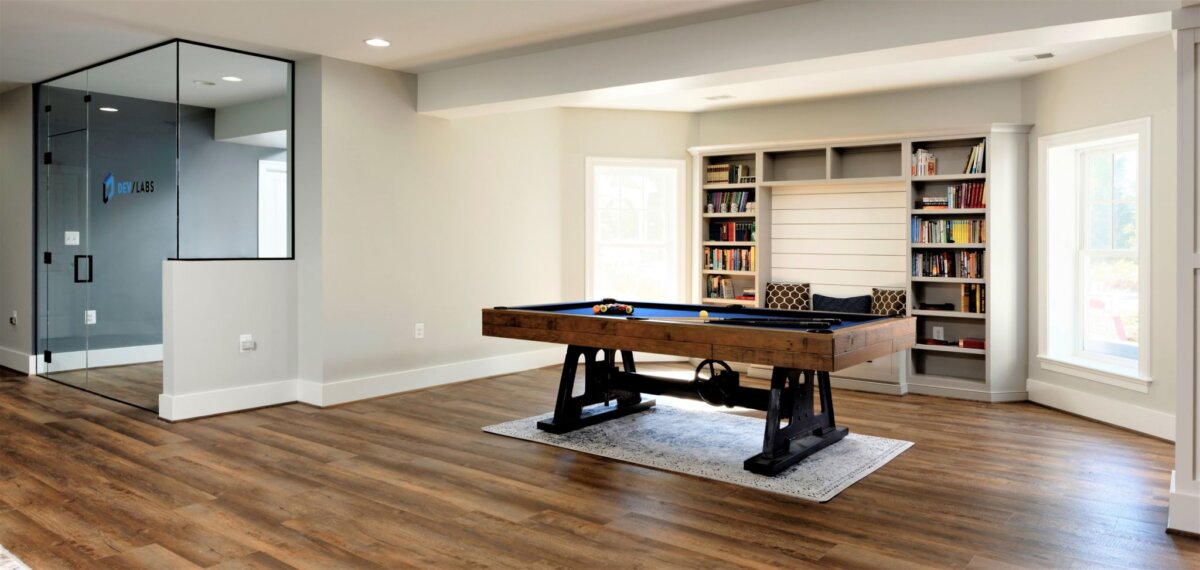 basement with glass wall and pool table book shelves