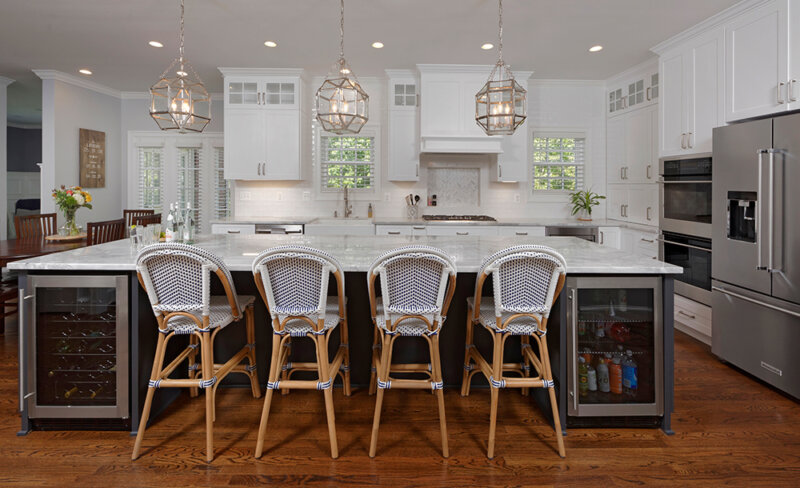 large kitchen island with refrigerators and chairs